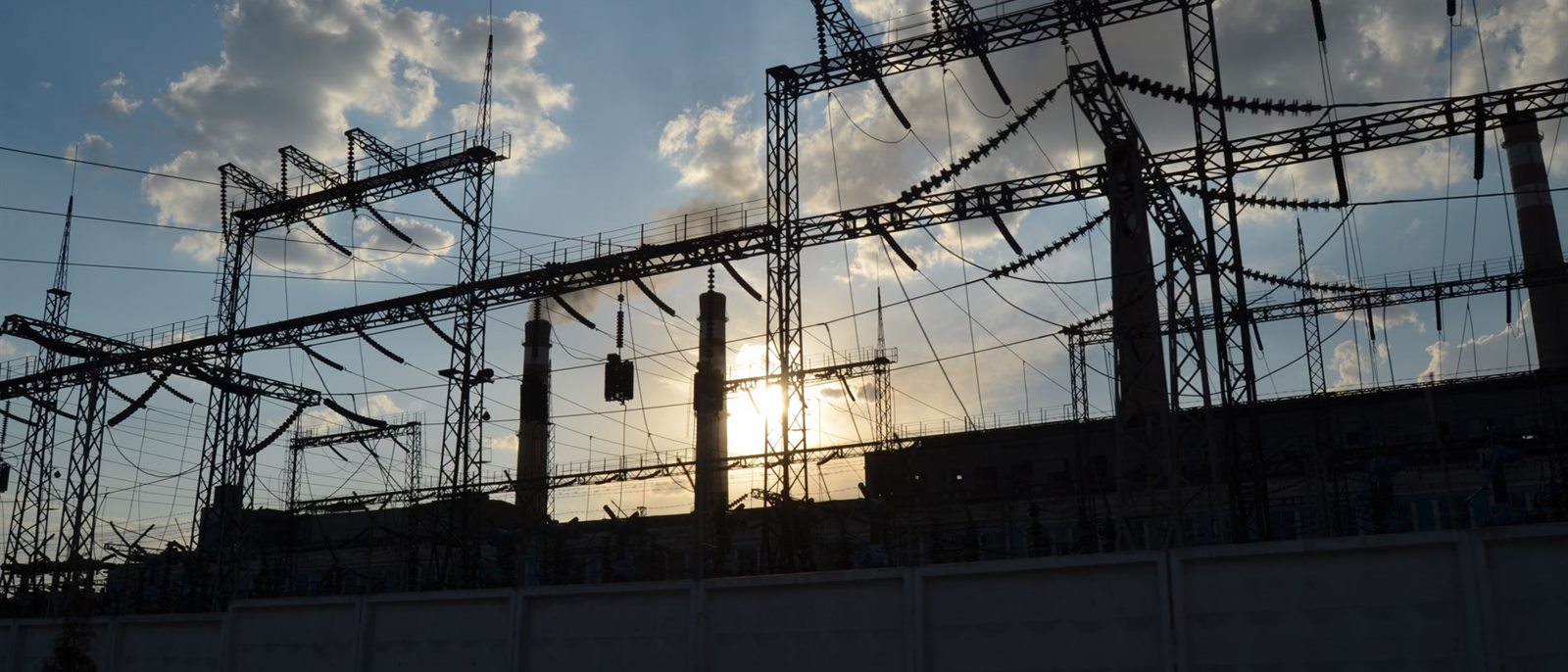 Utility switchyard and transmission gantries at sunset